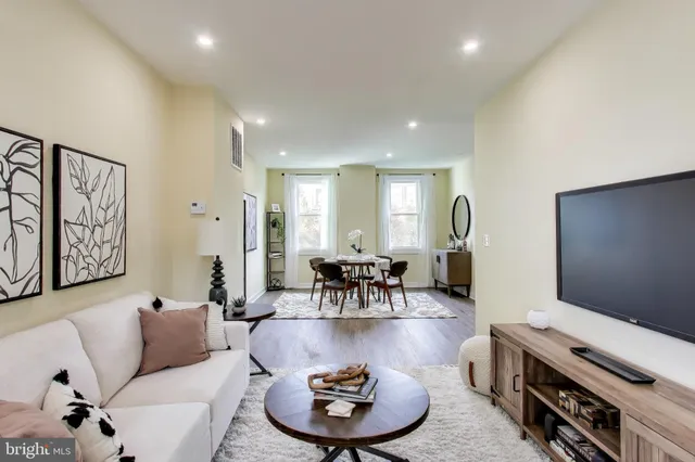 a living room with furniture a large window and gym equipment