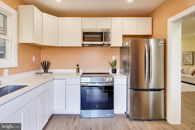 a kitchen with stainless steel appliances a refrigerator a sink a stove a microwave and cabinets