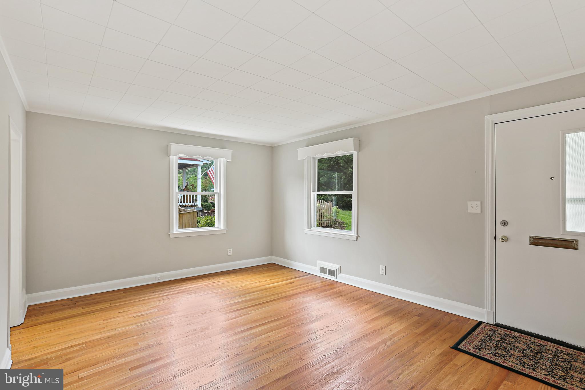 1813 Frederick Road Catonsville, MD 21228 - Photo 3 of 19 a view of an empty room with wooden floor and a window