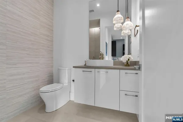 a bathroom with a granite countertop sink a toilet and a mirror