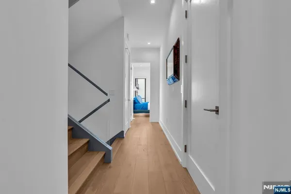 a view of a hallway with wooden floor and staircase