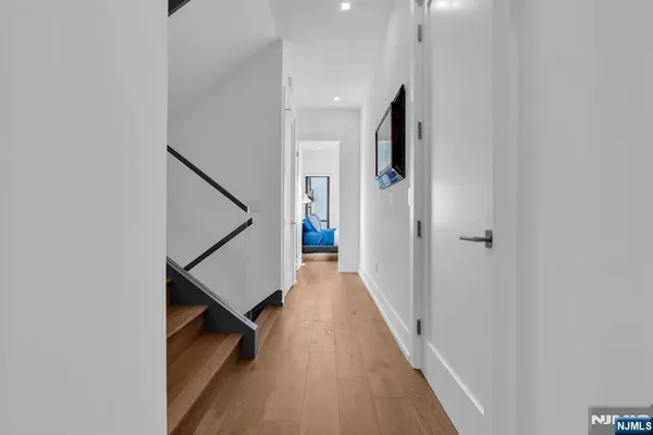 a view of a hallway with wooden floor and staircase