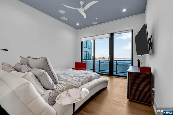 a bedroom with a balcony a bed and a flat screen tv