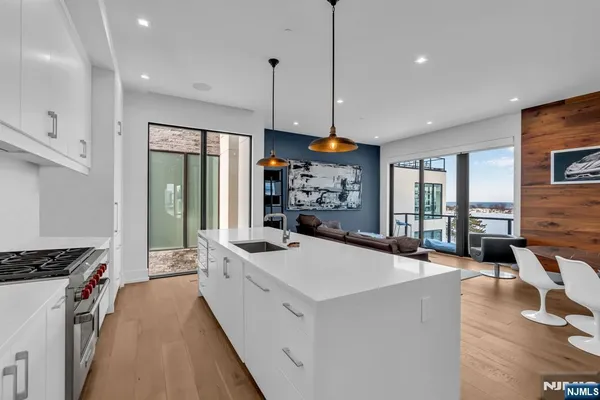 a open kitchen with stainless steel appliances granite countertop a lot of counter space and a wooden floor