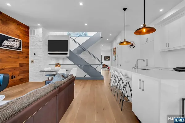 a kitchen with stainless steel appliances granite countertop a sink a stove and a wooden floors