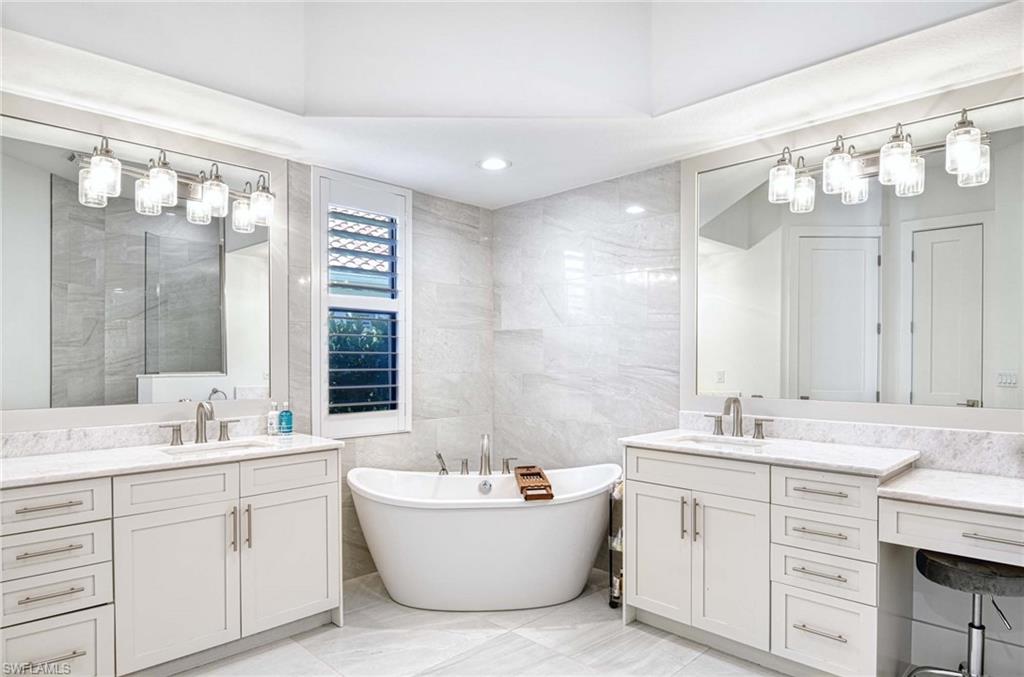 7516 Treeline Drive Naples, FL 34119 - Photo 13 of 33 a bathroom with a sink double vanity mirror and a bathtub