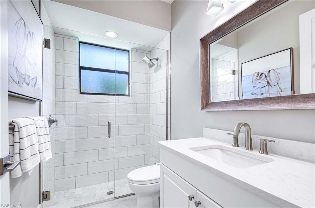 7516 Treeline Drive Naples, FL 34119 - Photo 16 of 33 a bathroom with a toilet sink and mirror