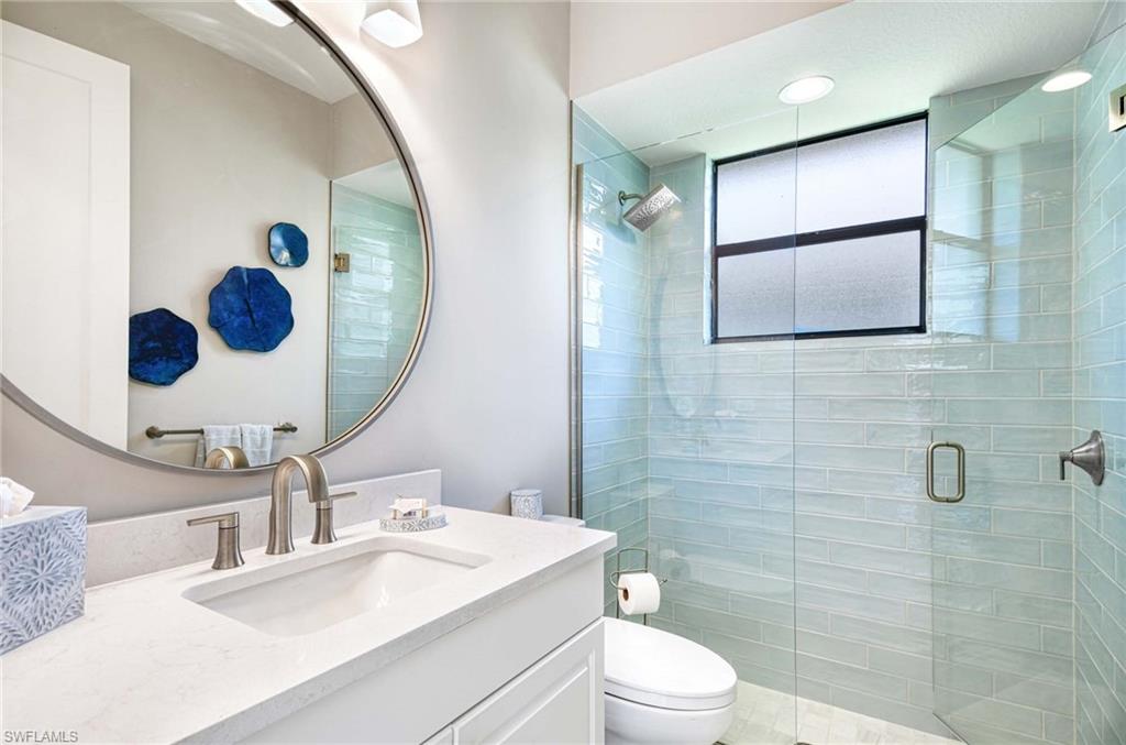 7516 Treeline Drive Naples, FL 34119 - Photo 18 of 33 a bathroom with a sink mirror and toilet