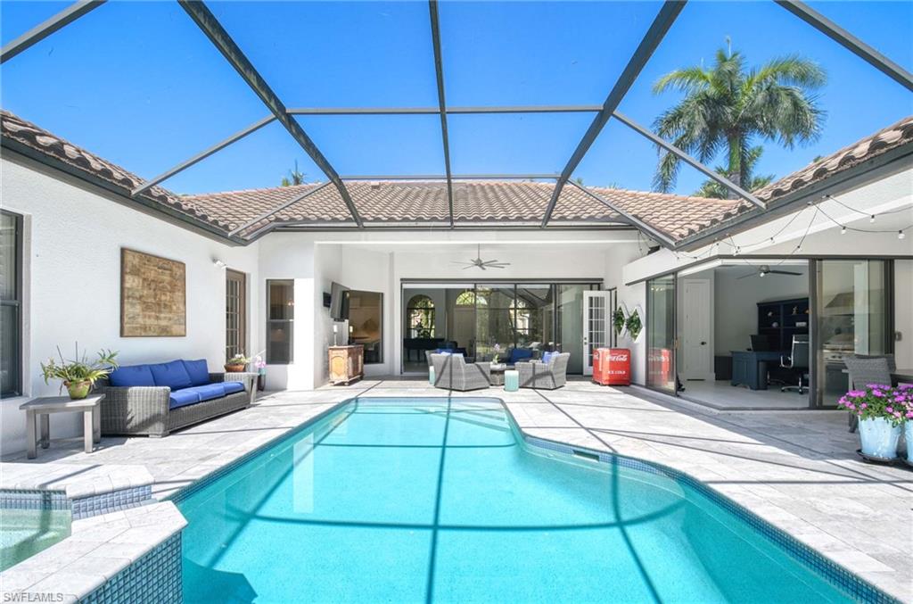 7516 Treeline Drive Naples, FL 34119 - Photo 4 of 33 a view of a patio with table and chairs potted plants with wooden floor