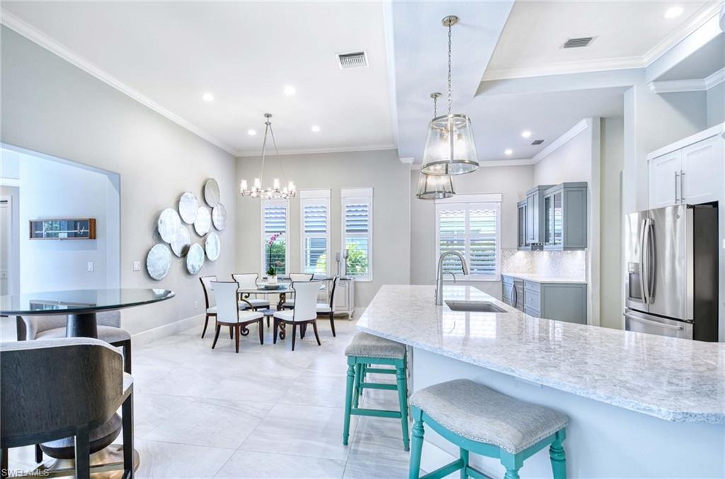 7516 Treeline Drive Naples, FL 34119 - Photo 8 of 33 a dining room with wooden floor a chandelier a wooden table and chairs