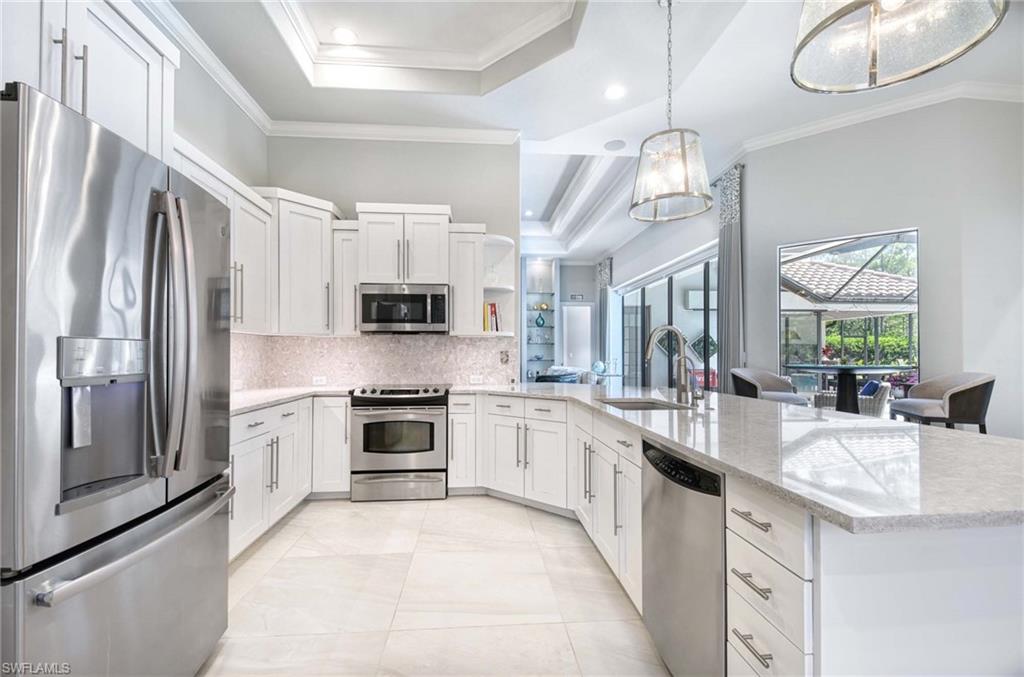 7516 Treeline Drive Naples, FL 34119 - Photo 9 of 33 a large white kitchen with stainless steel appliances granite countertop a stove and a sink
