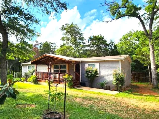 a view of a house with a yard patio and swimming pool