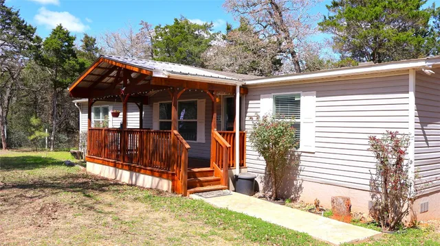 a view of a house with a yard and wooden fence