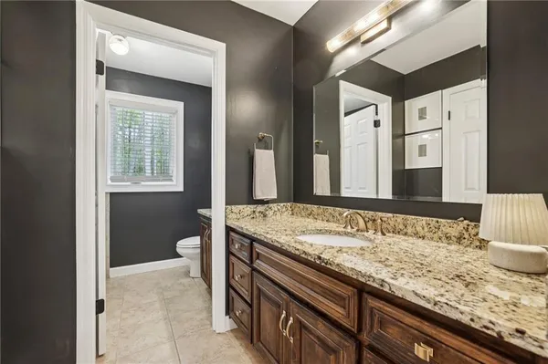 a bathroom with a granite countertop sink and a mirror