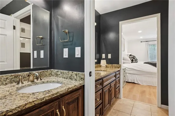a en suite bathroom with a granite countertop sink and a mirror