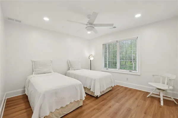 a bedroom with two beds and a chair
