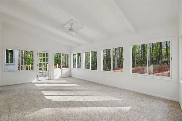 a view of an empty room with a fireplace and large windows