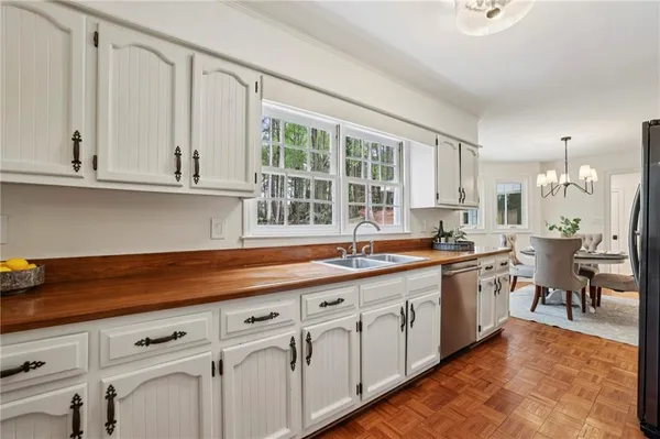 a kitchen with white cabinets and sink