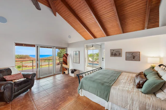 a bedroom with a bed a couch and large window with outer view