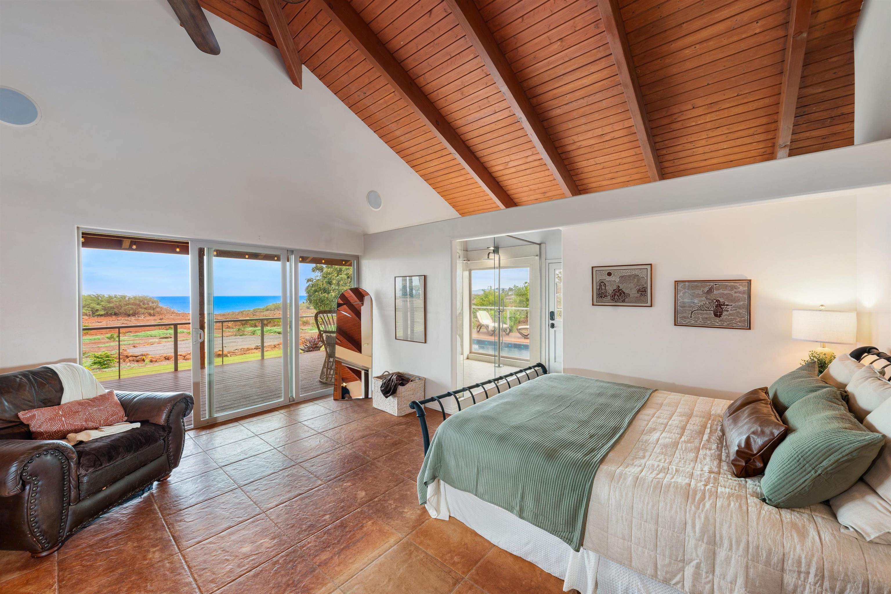 3820 Kalua Koi Road Maunaloa, HI 96770 - Photo 12 of 46 a bedroom with a bed a couch and large window with outer view