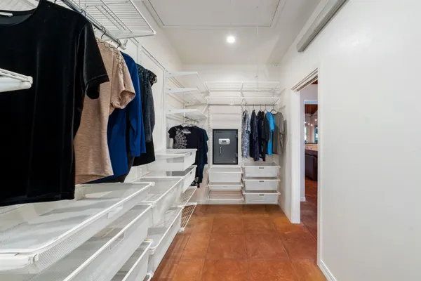 a view of walk in closet with clothes and shoes