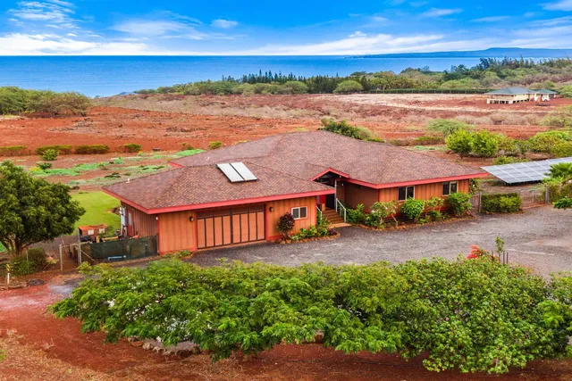 an aerial view of residential houses with outdoor space and ocean view
