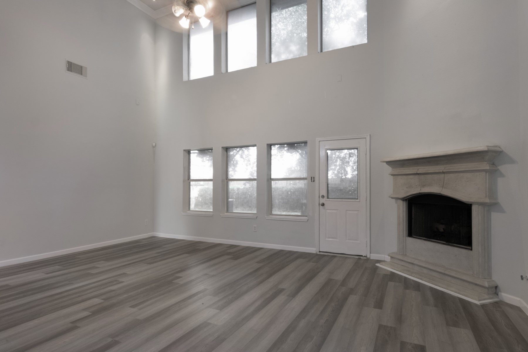5326 Coast Line Street Baytown, TX 77521 - Photo 4 of 26 an empty room with wooden floor fireplace and windows