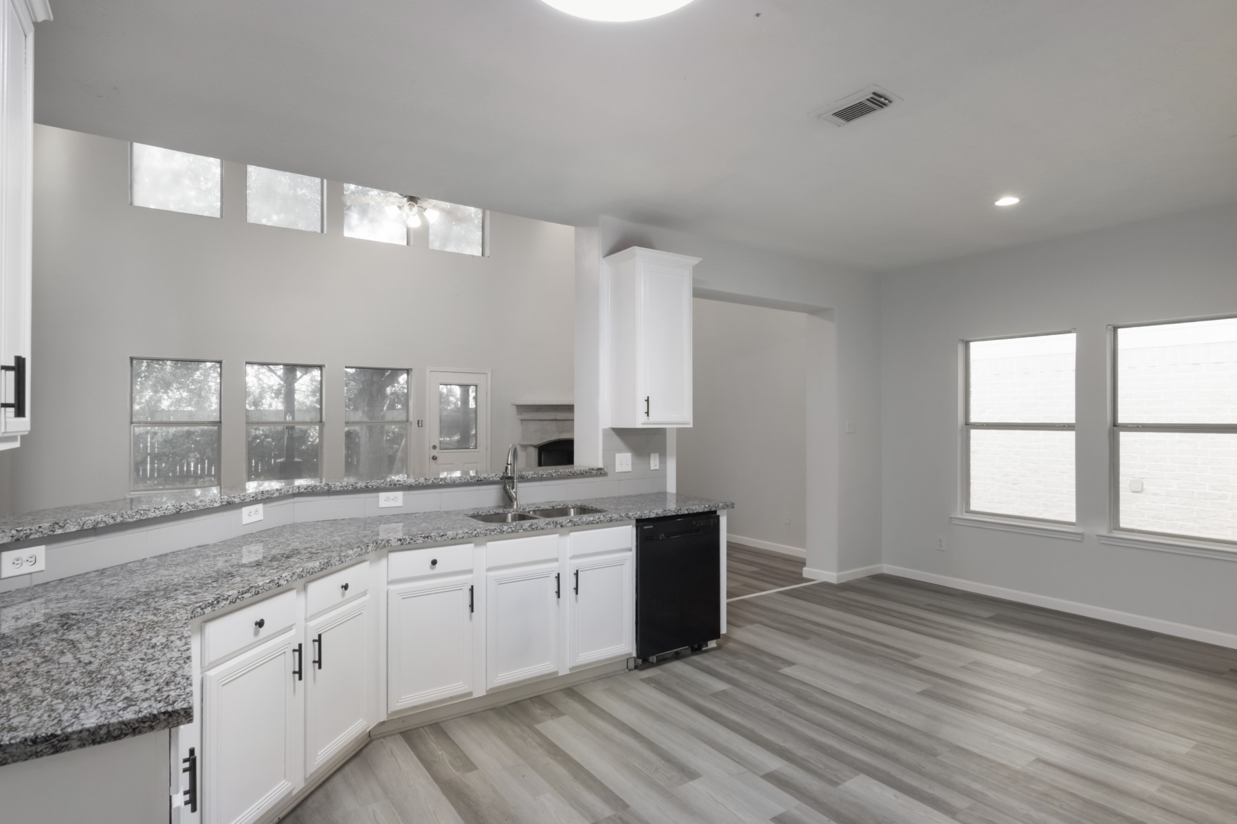 5326 Coast Line Street Baytown, TX 77521 - Photo 8 of 26 a large kitchen with stainless steel appliances granite countertop a sink dishwasher a stove and white cabinets with wooden floor