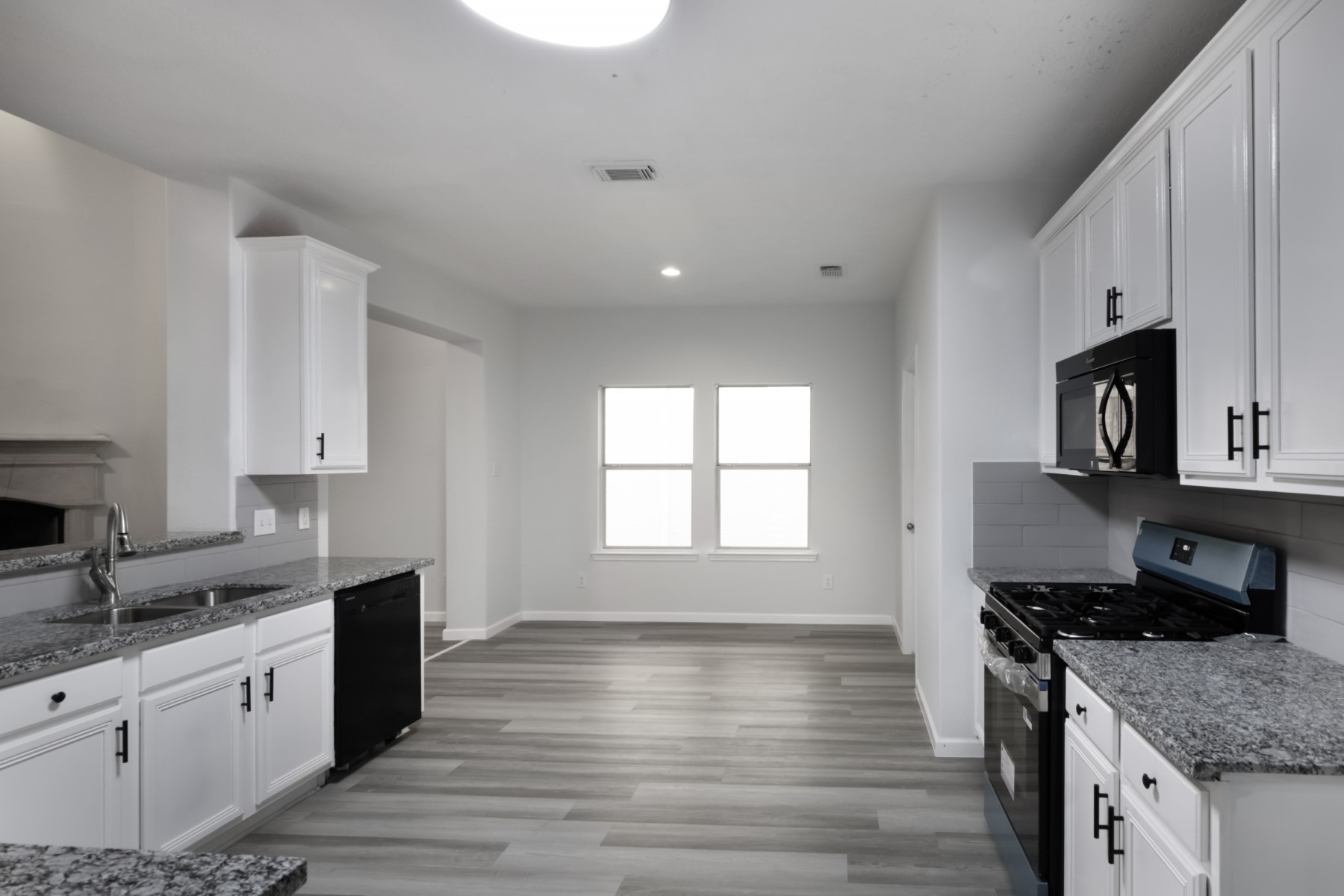 5326 Coast Line Street Baytown, TX 77521 - Photo 9 of 26 a kitchen with granite countertop a sink stove and cabinets