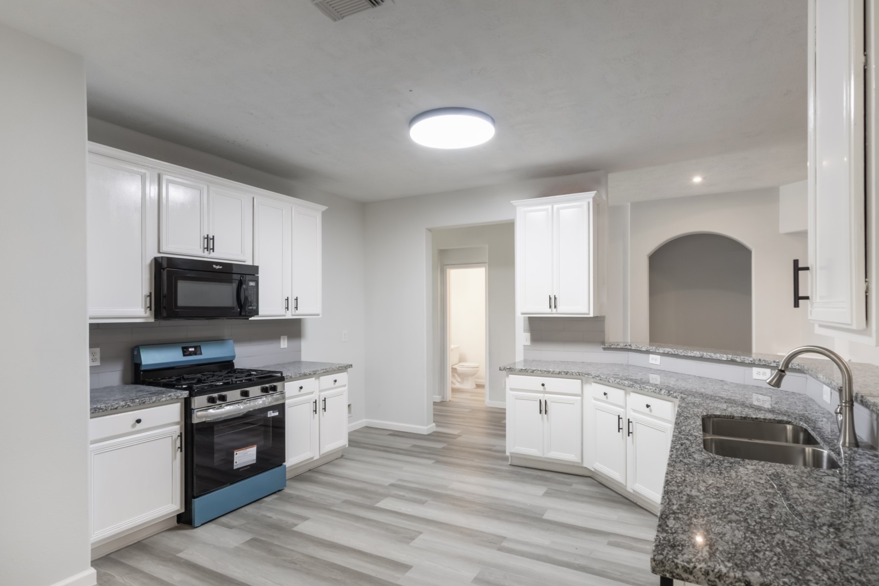 5326 Coast Line Street Baytown, TX 77521 - Photo 10 of 26 a large kitchen with stainless steel appliances granite countertop a stove top oven a sink a counter space and cabinets