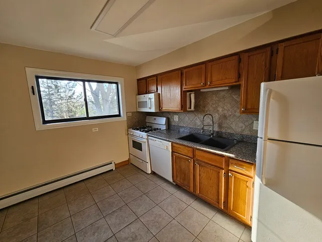 a kitchen with stainless steel appliances granite countertop a refrigerator sink and stove