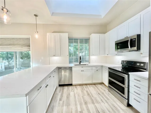 a kitchen with a sink stove and microwave