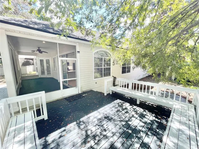 a view of a hallway with wooden floor and a bathroom