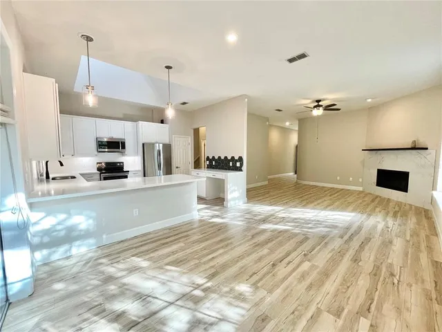 a view of an empty room with a fireplace and a window