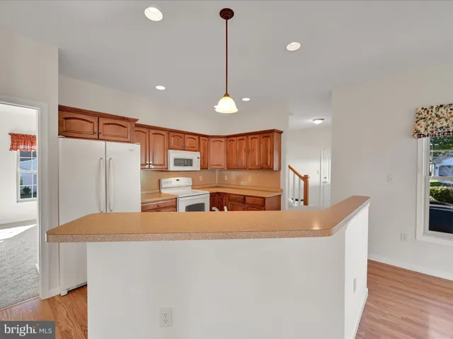 a kitchen with stainless steel appliances granite countertop a sink a refrigerator and a stove