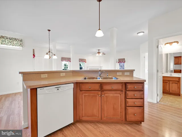 a kitchen with a sink cabinets and wooden floor