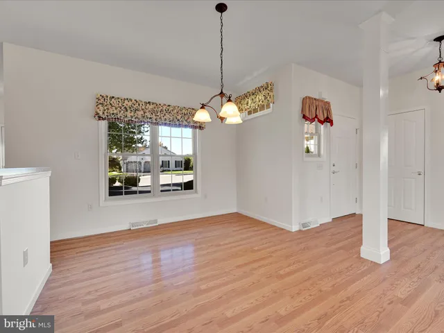 a view of a room with wooden floor a sink and a window
