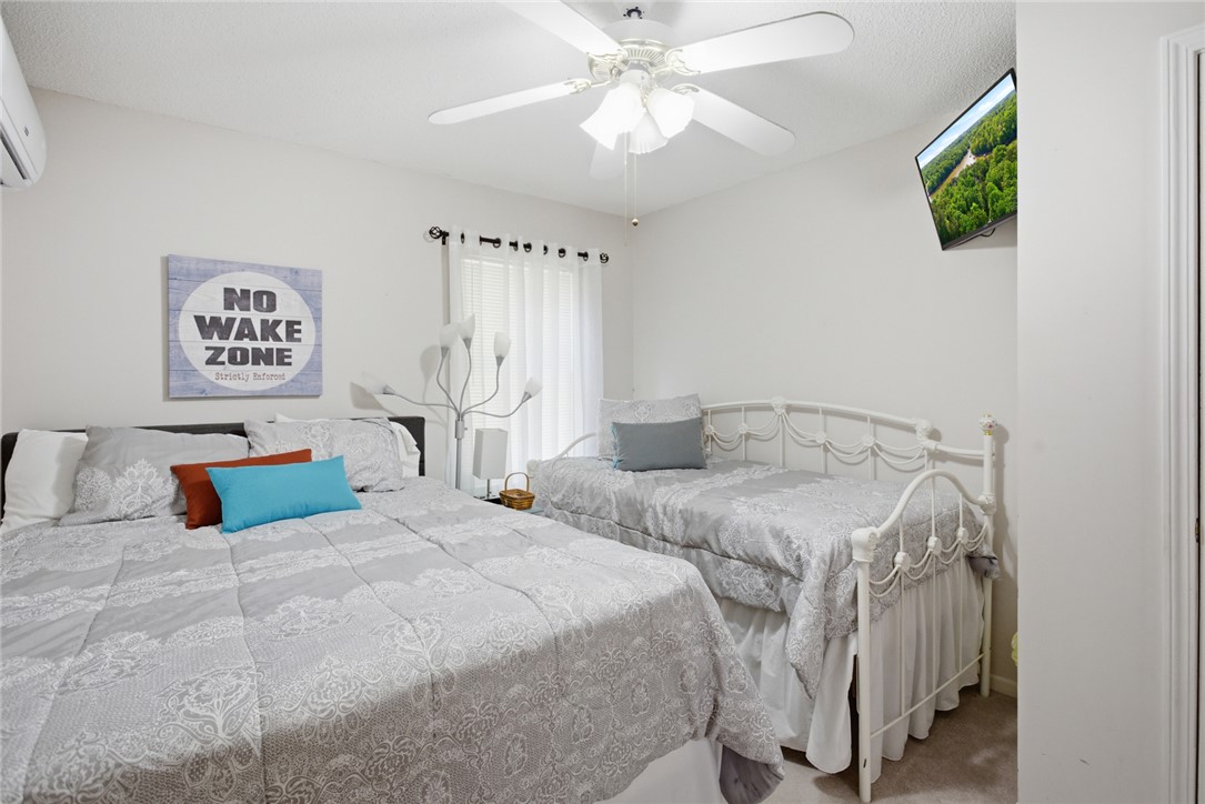 110 Snug Harbor Road Seneca, SC 29678 - Photo 20 of 37 This cozy bedroom features comfortable beds, a bright window, and a ceiling fan for optimal comfort.