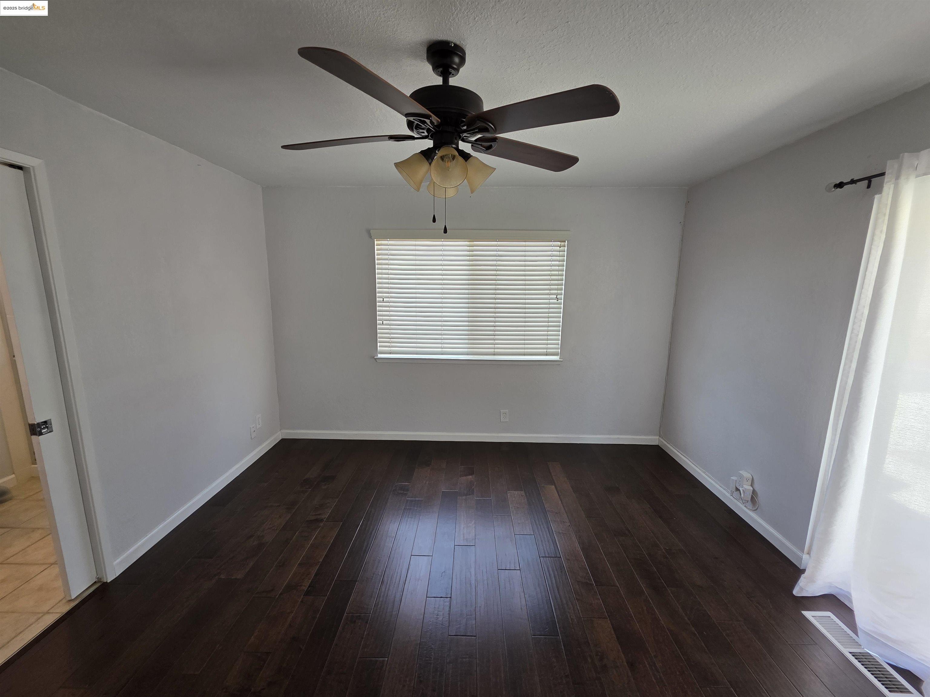 136 Evergreen Way Vallejo, CA 94591 - Photo 13 of 51 a view of an empty room with wooden floor and a window