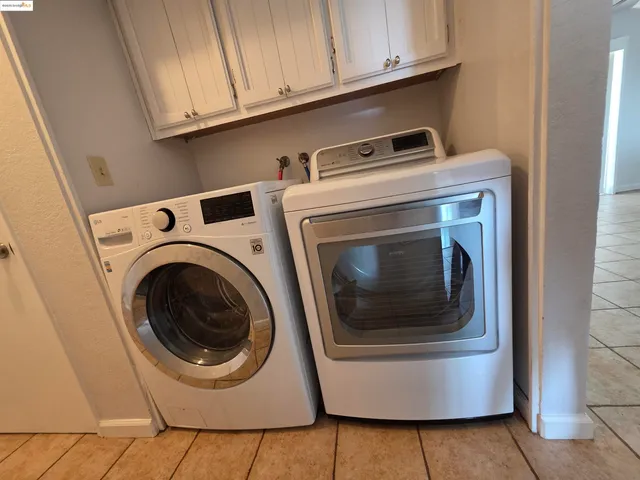 an empty room with wooden floor chandelier fan and windows