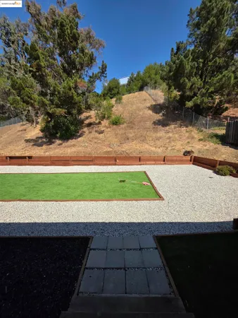 a view of a backyard with wooden fence