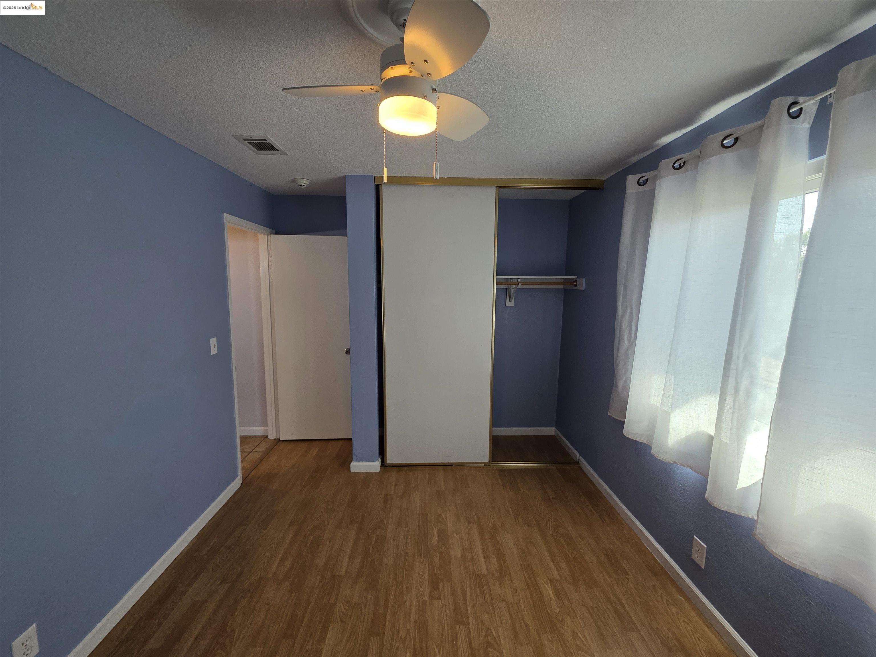 136 Evergreen Way Vallejo, CA 94591 - Photo 3 of 51 a view of empty room with wooden floor and fan