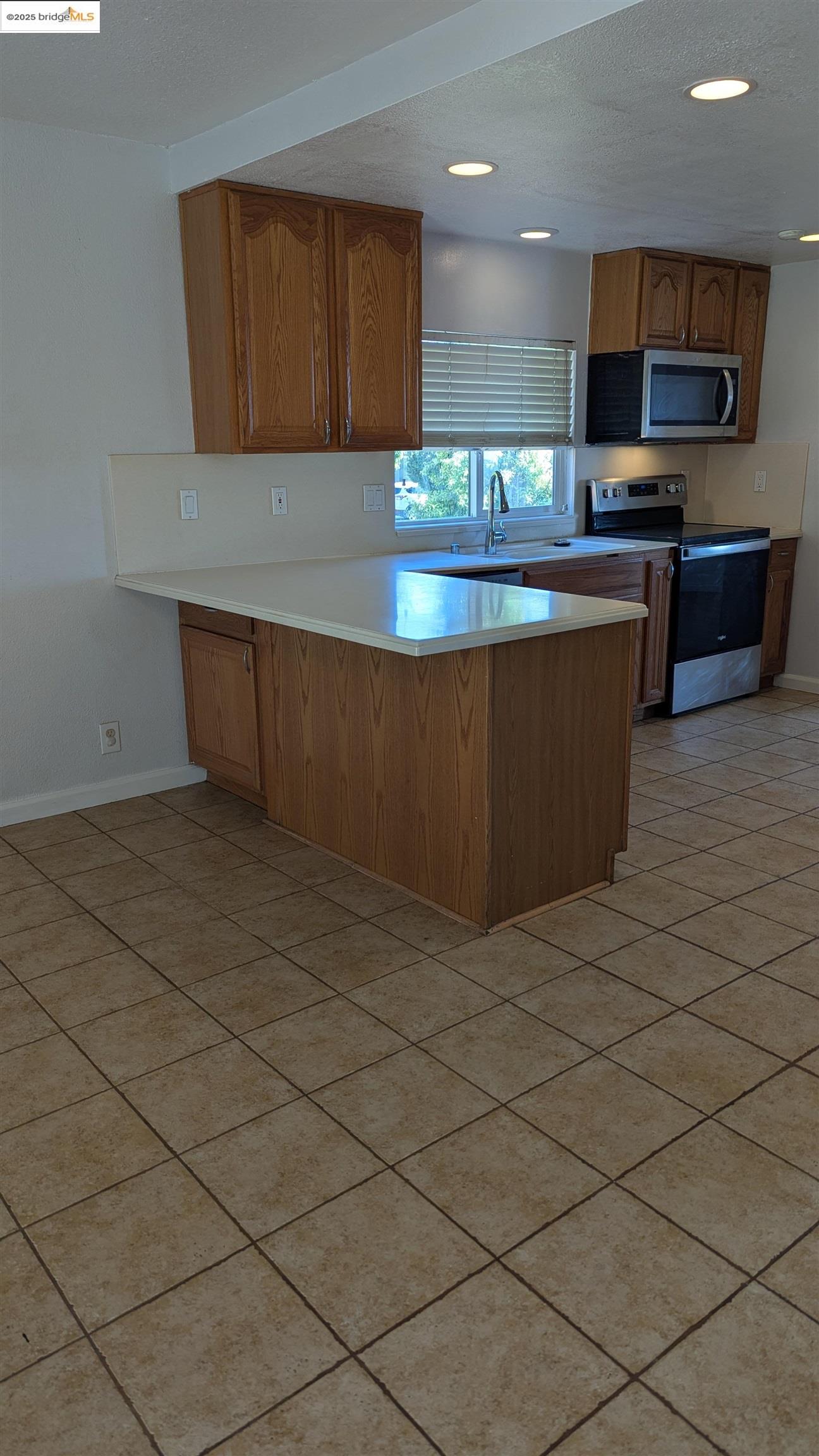 136 Evergreen Way Vallejo, CA 94591 - Photo 7 of 51 a kitchen with stainless steel appliances granite countertop a stove a sink and a microwave