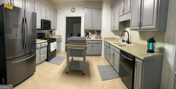 a kitchen with stainless steel appliances granite countertop a refrigerator stove and sink