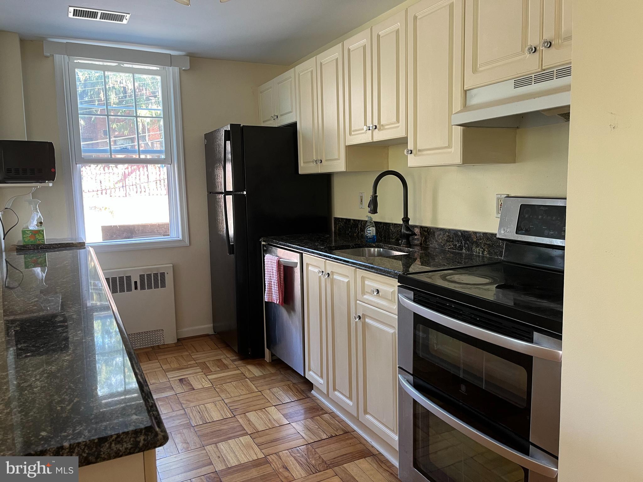 310 Ridgemede Road, Unit 207 Baltimore, MD 21210 - Photo 7 of 32 a kitchen with granite countertop a stove sink and refrigerator