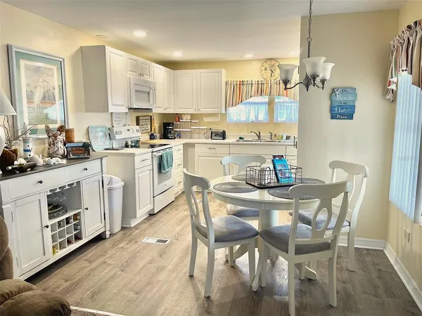 a kitchen with stainless steel appliances a white table and chairs in it