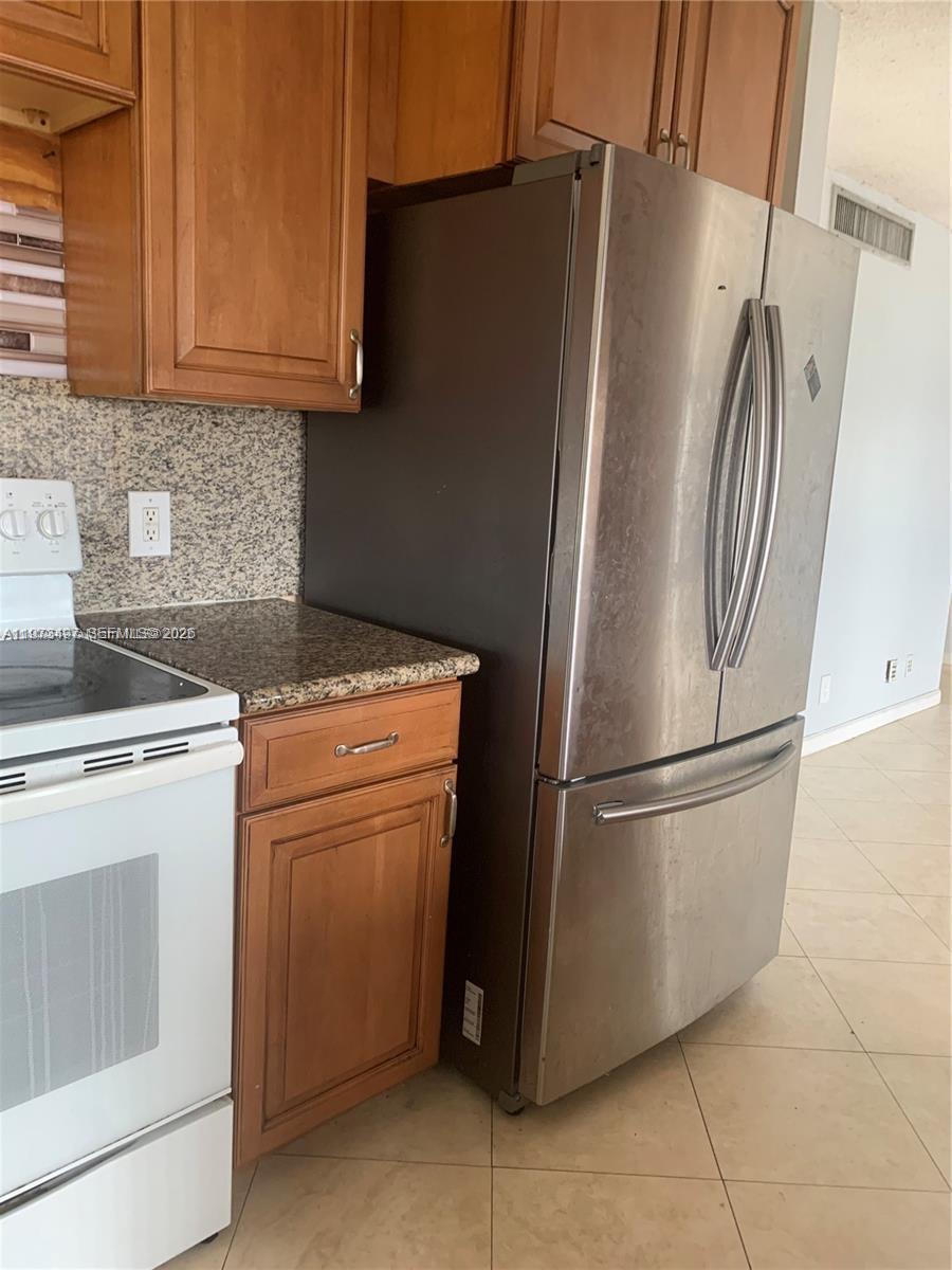 4222 Inverrary Boulevard, Unit 4415 Lauderhill, FL 33319 - Photo 6 of 11 a white refrigerator freezer and a stove sitting inside of a kitchen