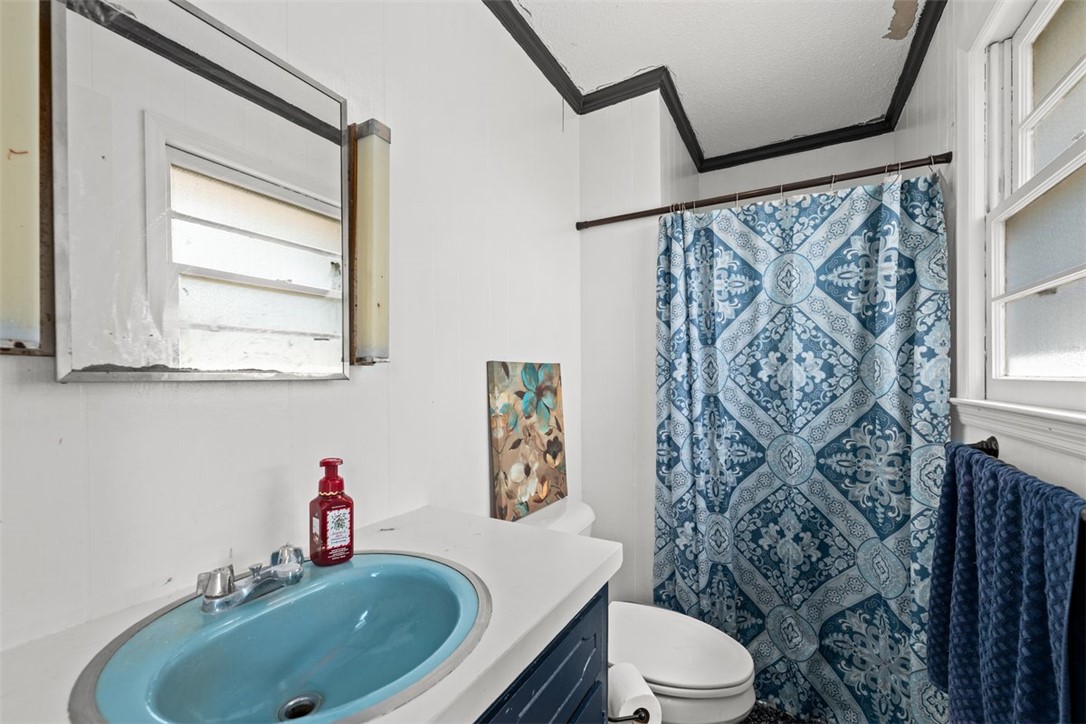 606 County Rd S-1-149 Donalds, SC 29638 - Photo 29 of 38 This bright bathroom features a blue sink and complementary patterned shower curtain for a serene atmosphere.