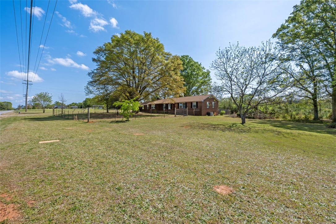 606 County Rd S-1-149 Donalds, SC 29638 - Photo 3 of 38 This expansive lot offers ample space with mature trees and a charming brick residence.