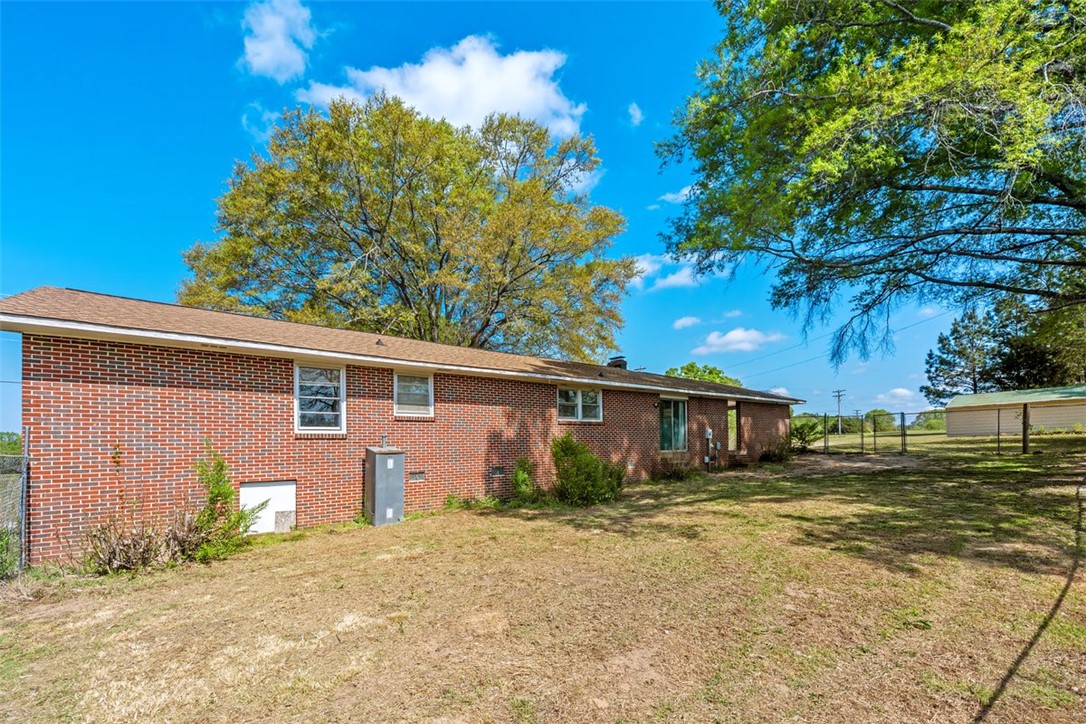 606 County Rd S-1-149 Donalds, SC 29638 - Photo 32 of 38 This expansive backyard features a classic brick home with ample green space.